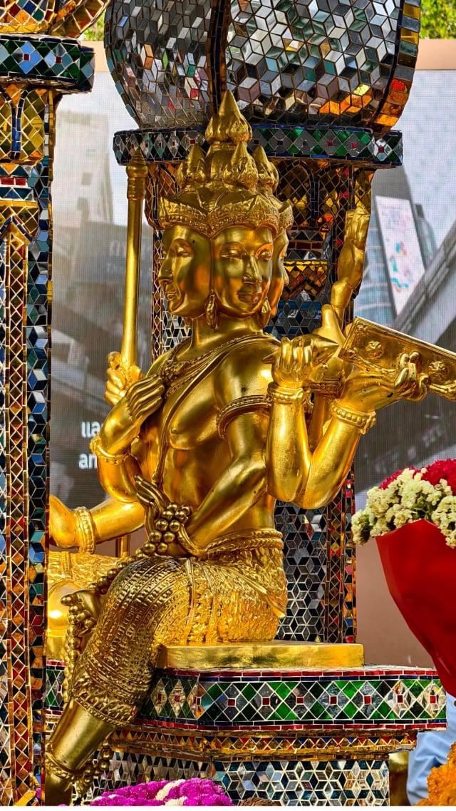 Close-up of the gilded face and figure of the Four-Faced Brahma image