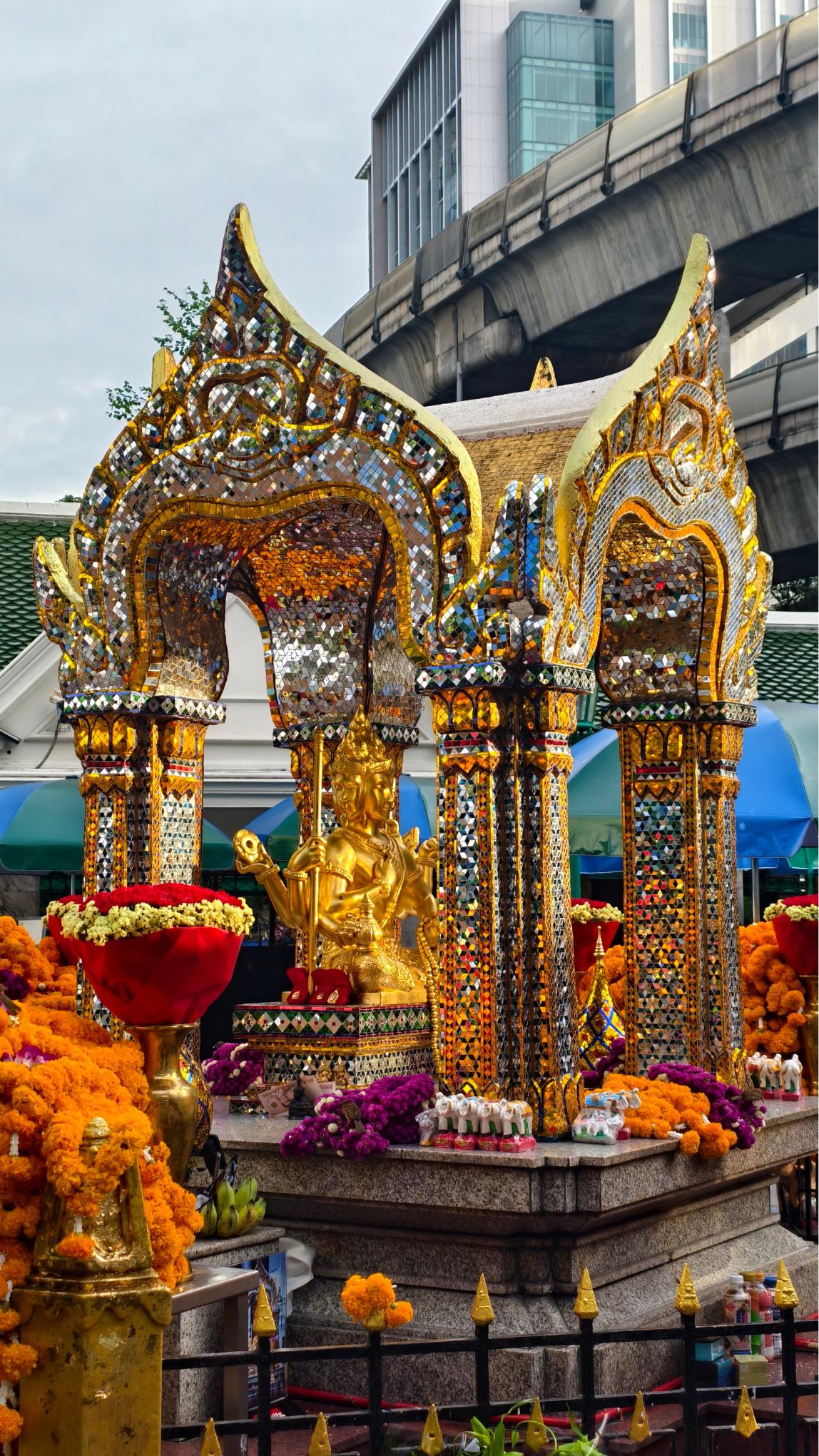 ศาลาประดิษฐานพระพรหมเอราวัณ มองเห็นรางรถไฟฟ้า BTS ด้านหลัง