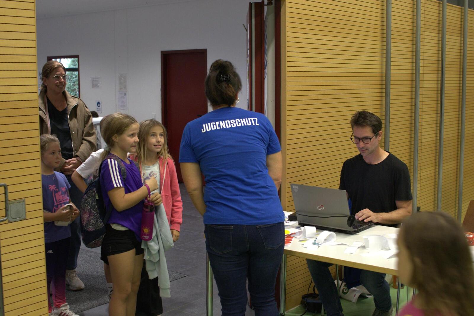 Nadine und Mark empfangen die Kinder am Eingang