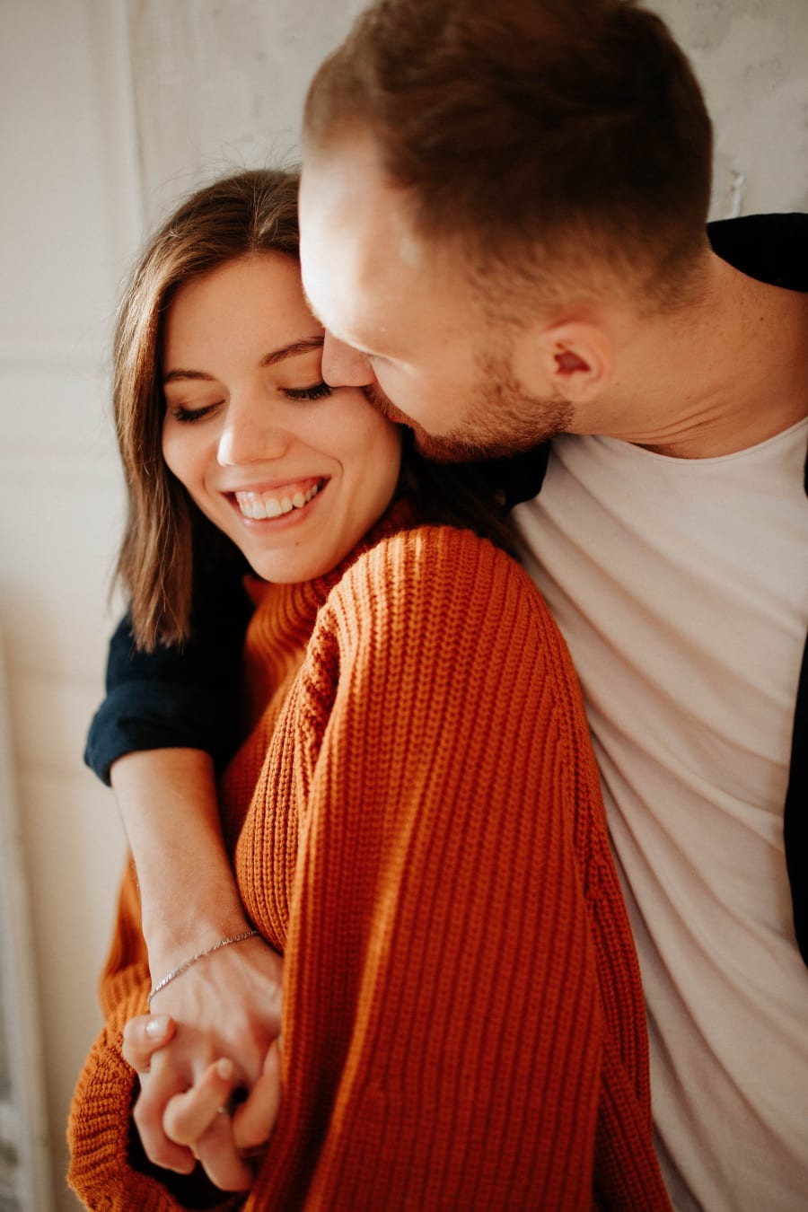 A couple laughing together at home.
