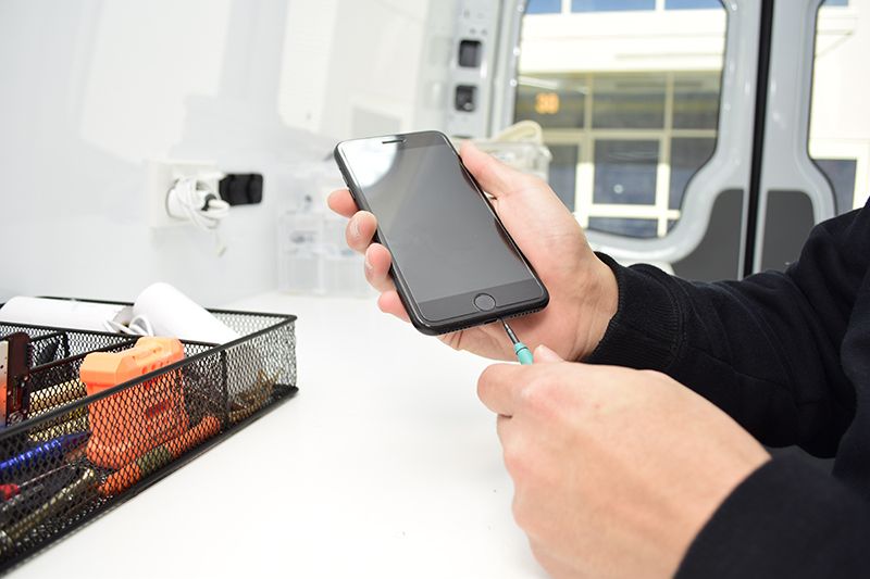 Technician displaying recently repaired iPhone