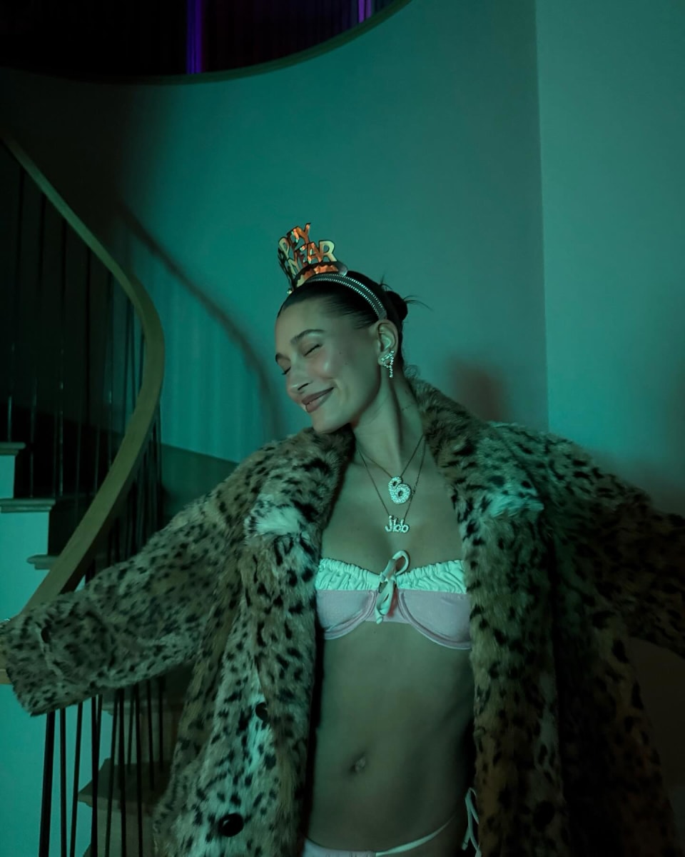 Hailey Bieber wearing a leopard-print faux fur coat over a pink bikini by With Jean swimwear line