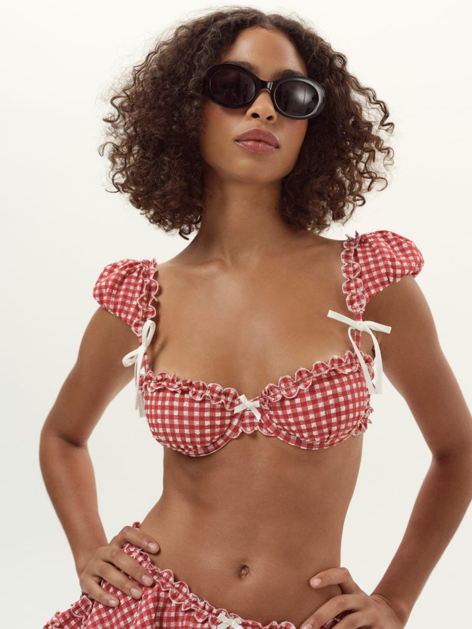 Close-up of For Love and Lemons Alison red gingham underwire balconette bikini top with white bow detail and capped puff sleeves