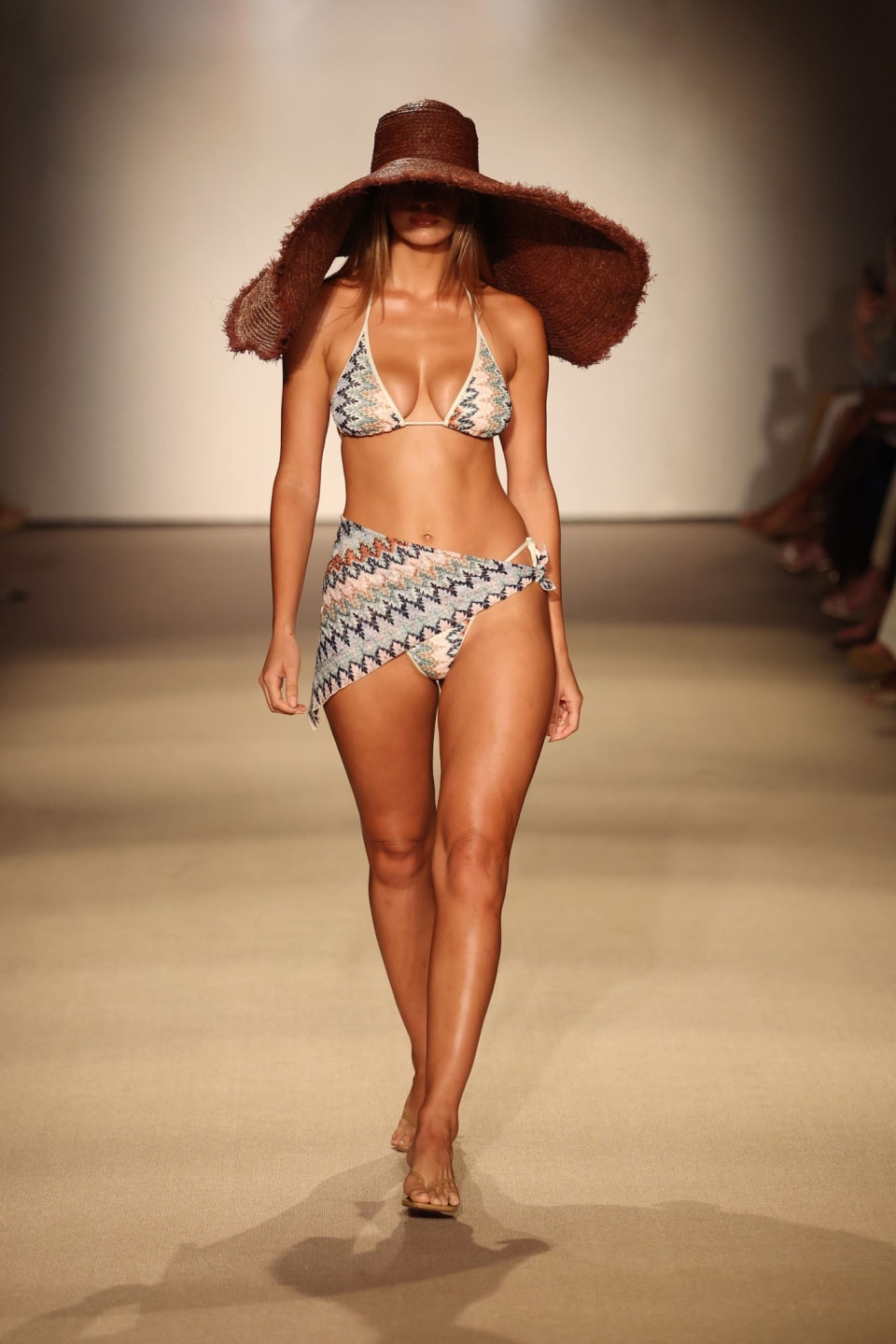 Monday Swimwear Palma color-block triangle top in multicolor zigzag knit styled on a runway with oversized straw hat