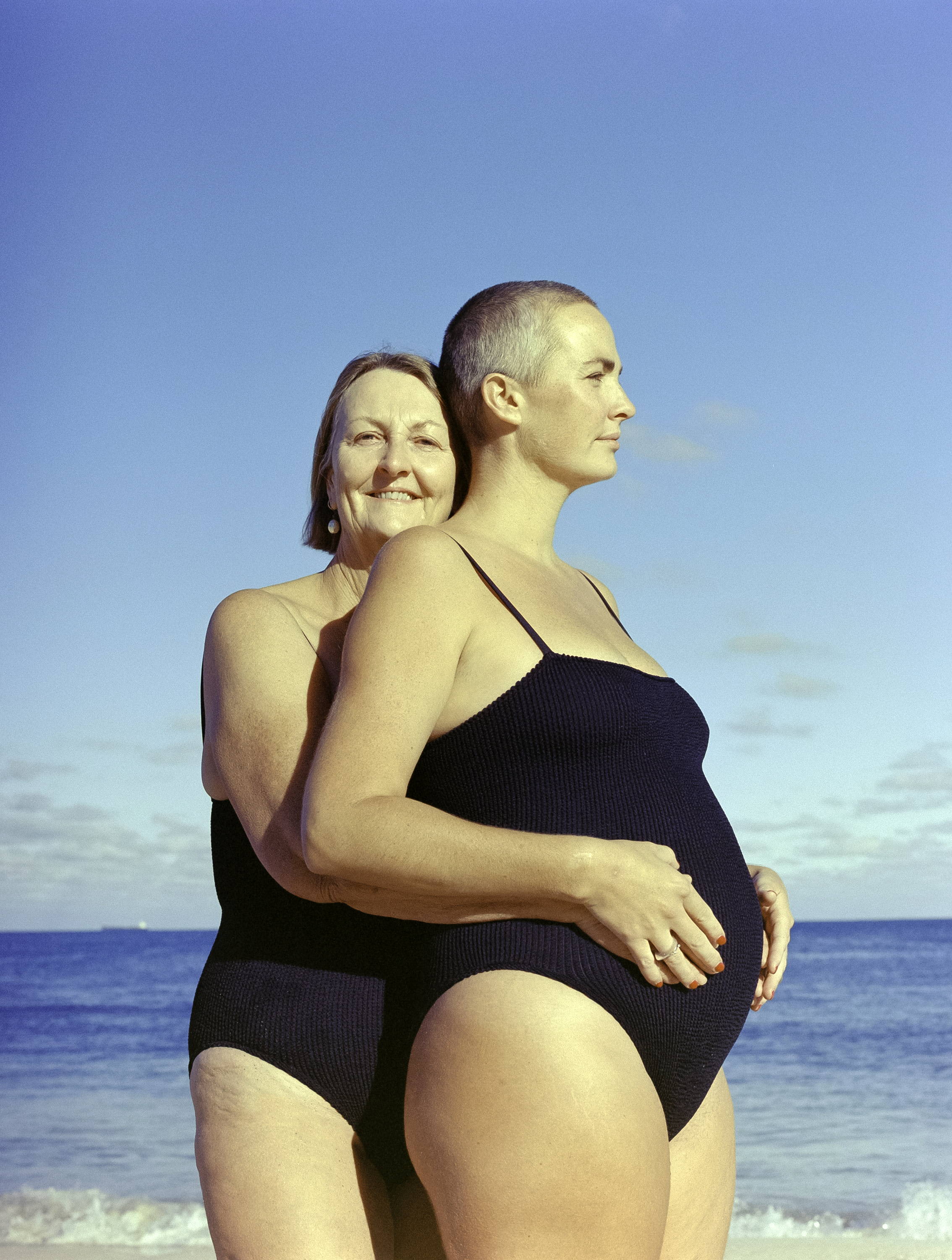 Photo of two women wearing a black one-piece by Youswim. May be mother and daughter.