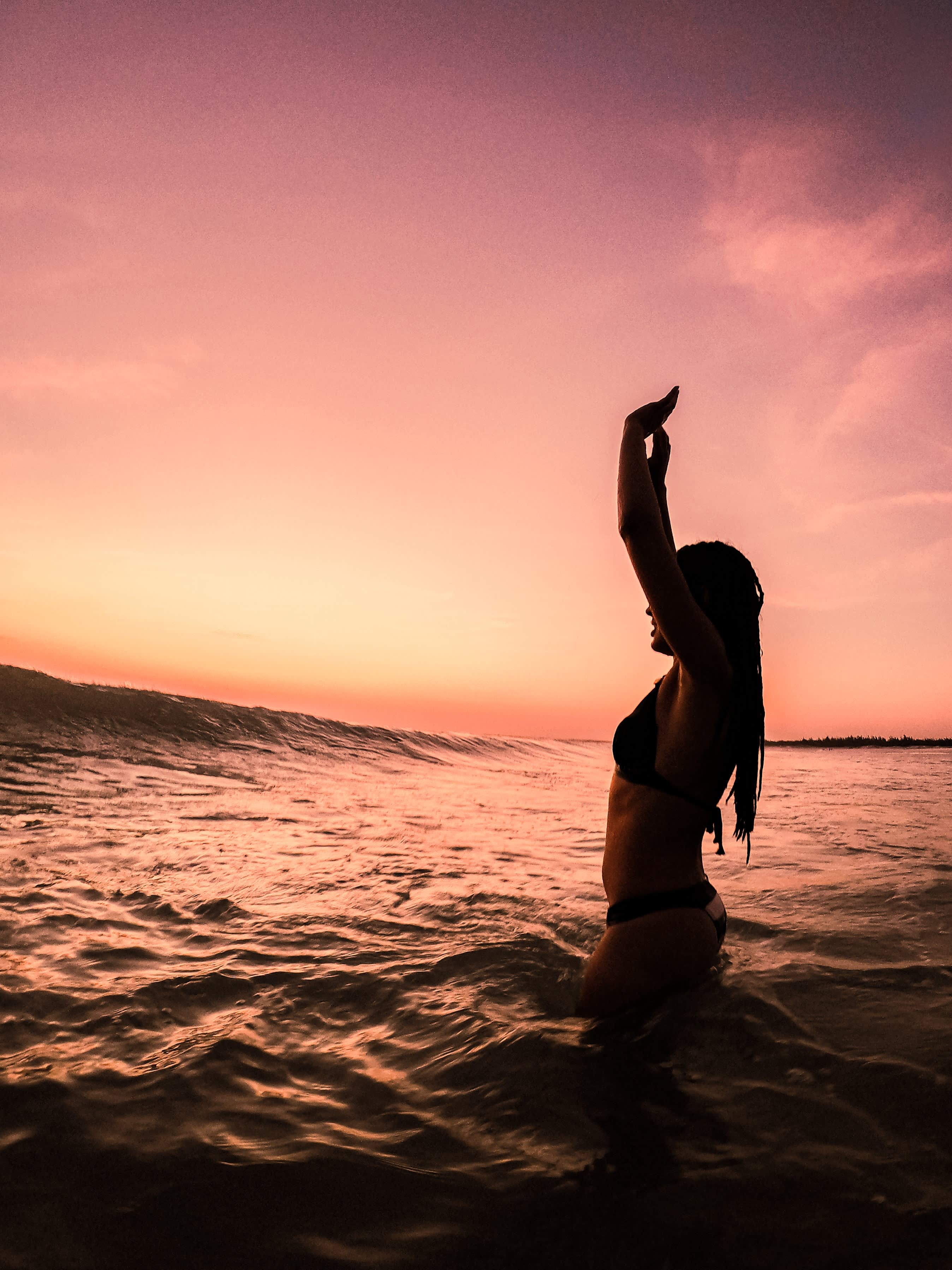 Photo of a woman in the sea at sunset