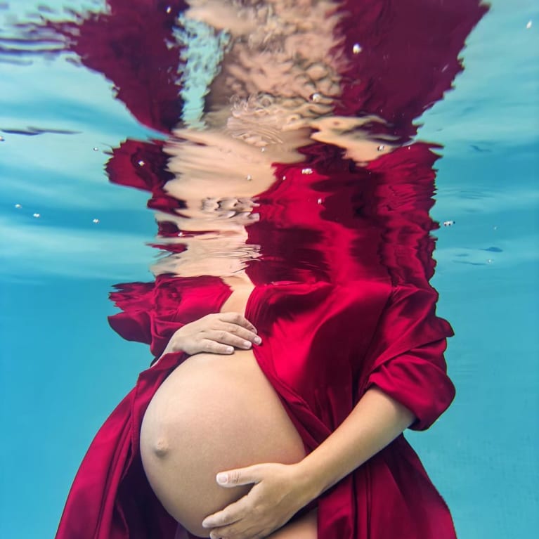 Cover Image of a pregnant woman underwater with a red dress