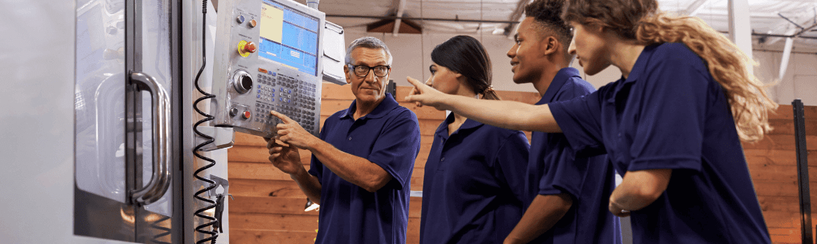 Swiss Apprenticeship Professions in the tool shop with their trainer, CNC machine, trainer showing the CNC programing comp