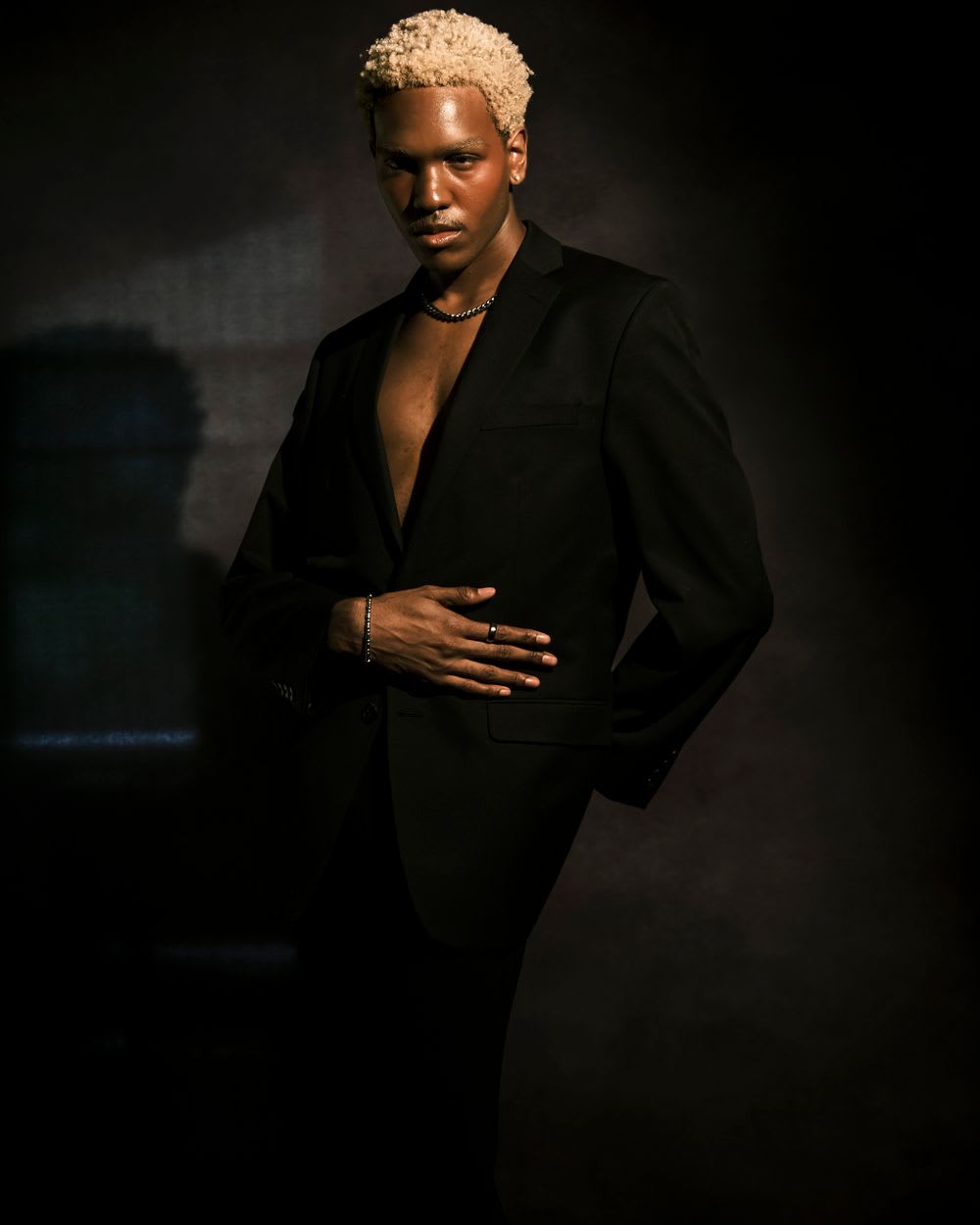 Male model in a dark studio with dramatic shadows