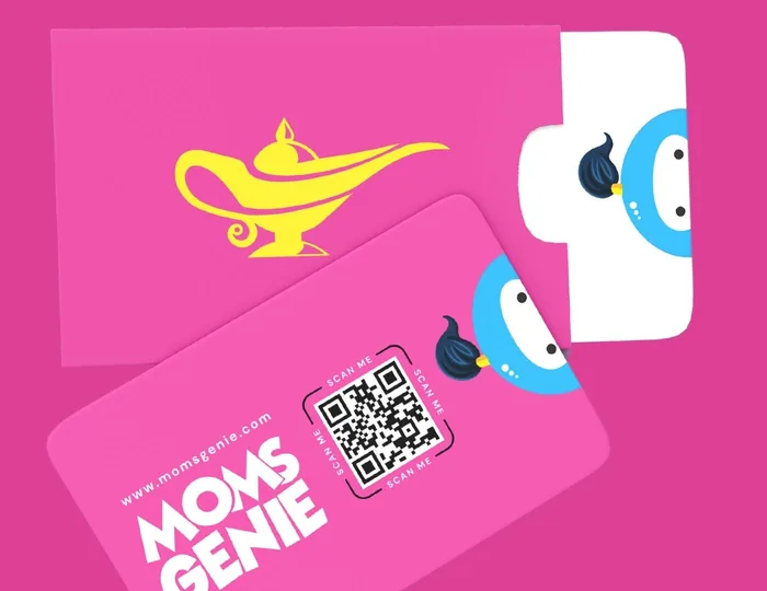 MomsGenie stationery on pink: an envelope with a yellow lamp and cards where Wishie peeks in from the edge