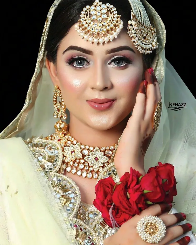 Nehaz Bridal Makeup content: a bride in gold kundan jewellery and a pale dupatta, photographed close, with the Nehazz mark in the corner