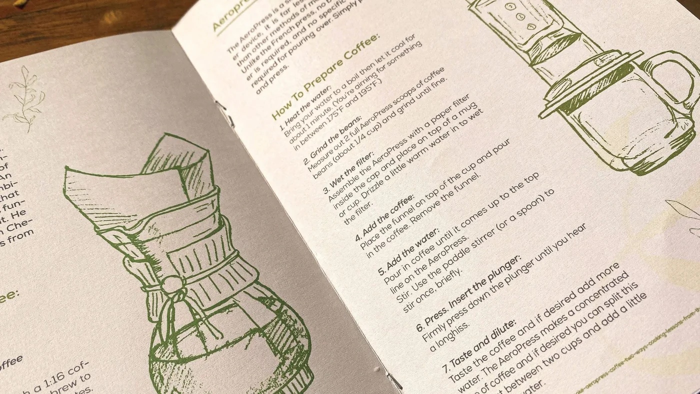 An open Oroblanco booklet: coffee brewing steps beside fine green line drawings of brewing equipment