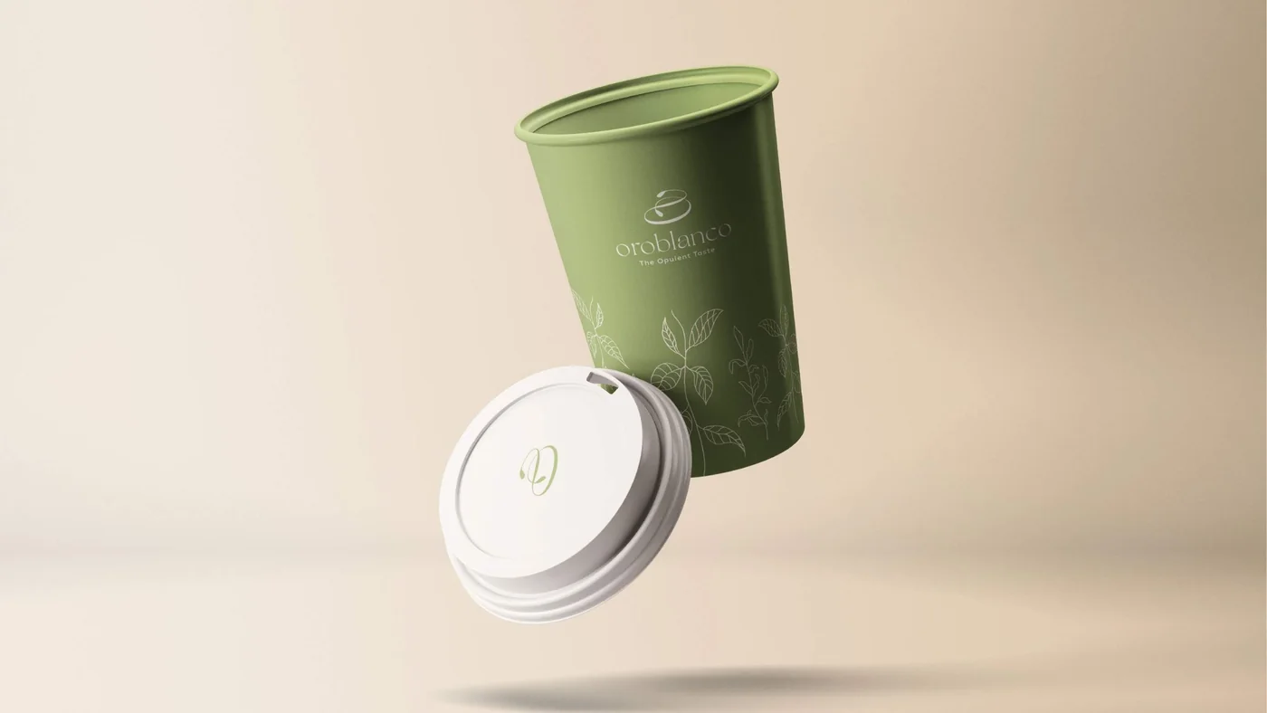 An Oroblanco takeaway cup in soft green with fine white leaf drawings and a white lid