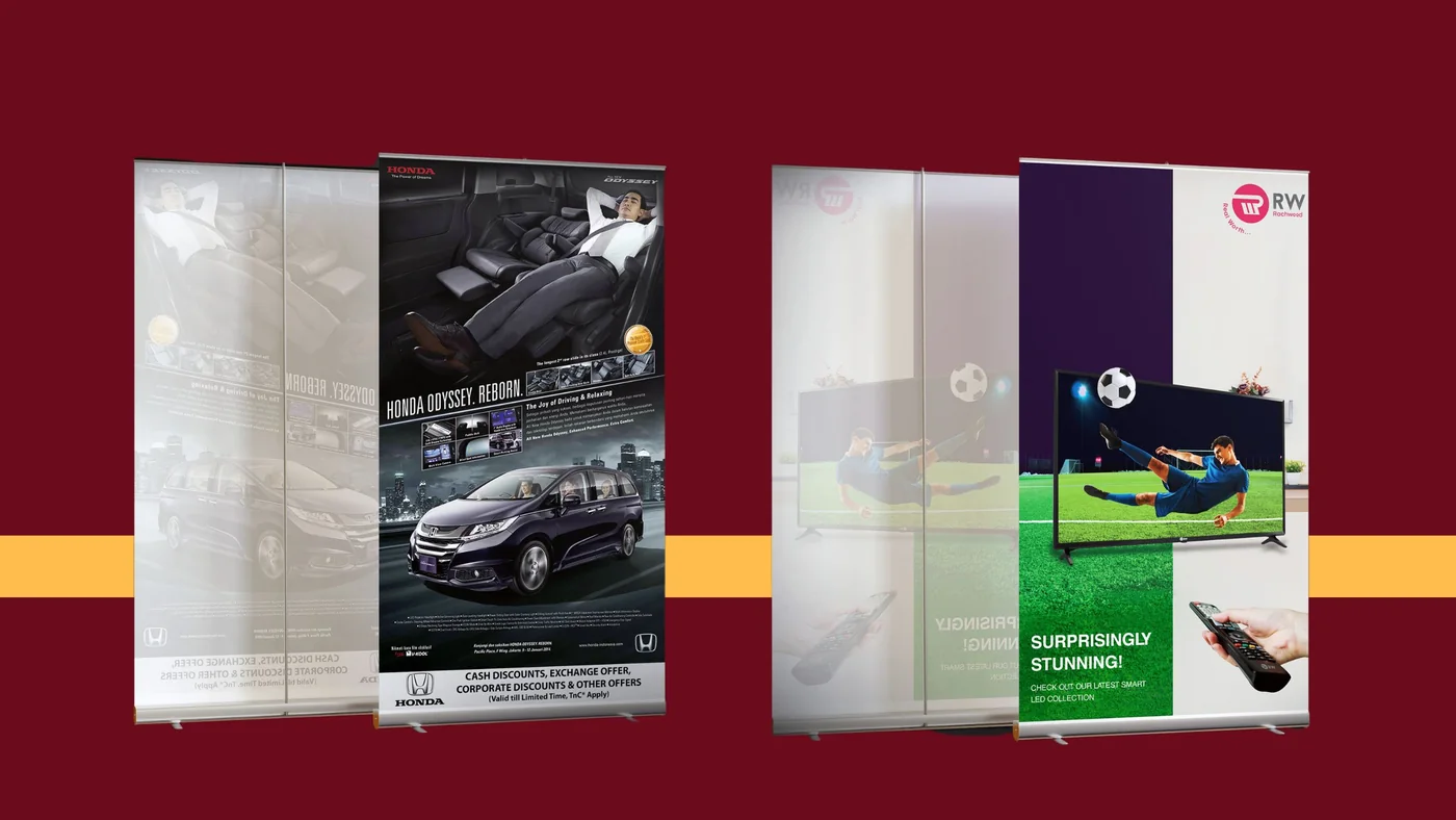 Two roll-up standees on maroon: a Honda Odyssey with dealer offers, and a footballer bursting from a smart TV