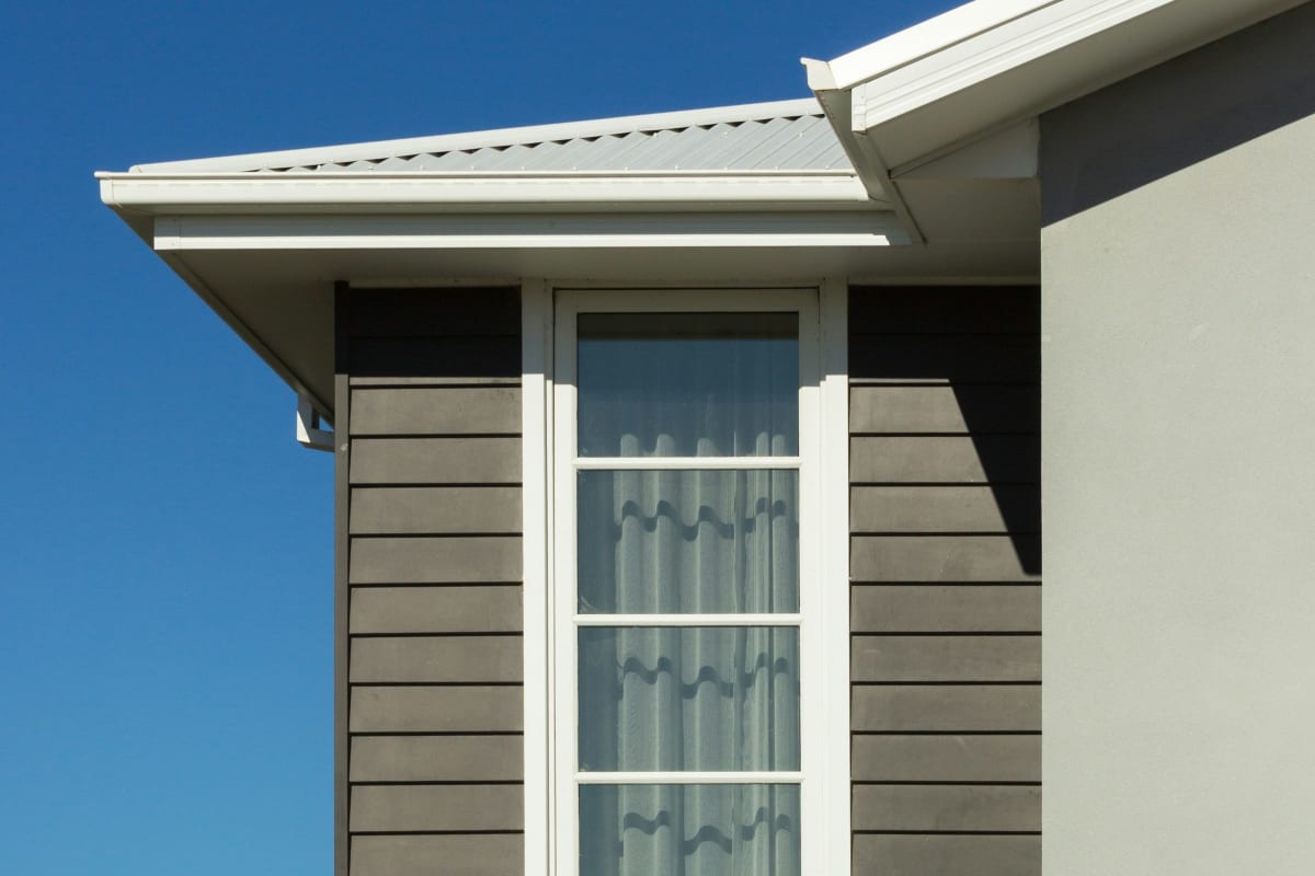 Gray lap siding around a white-trimmed window