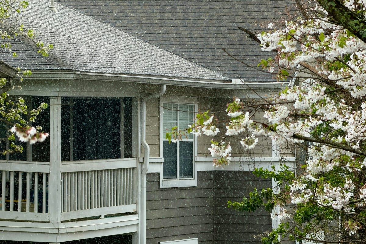 Spring rain falling on a porch roof and gutters