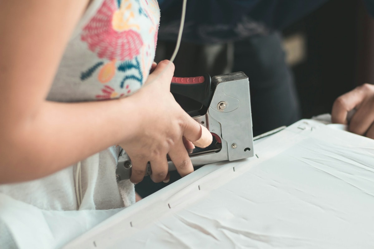 Stapling fabric to a frame with a staple gun