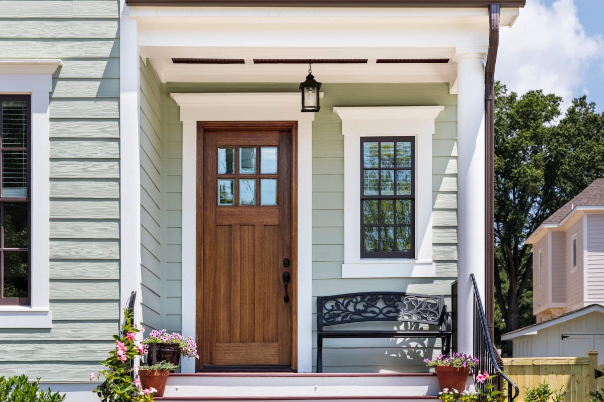 Front porch with crisp white trim around a wood entry door