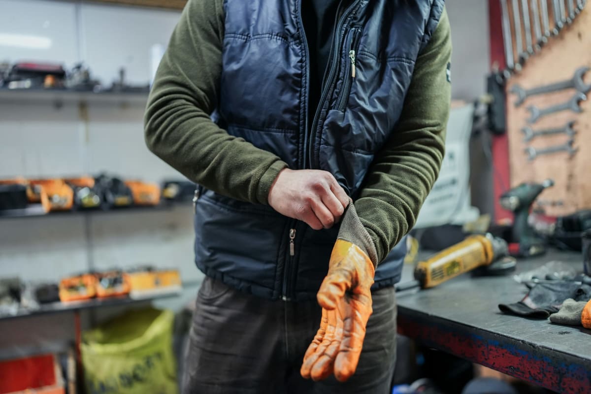 Mechanic pulling on work gloves in a shop