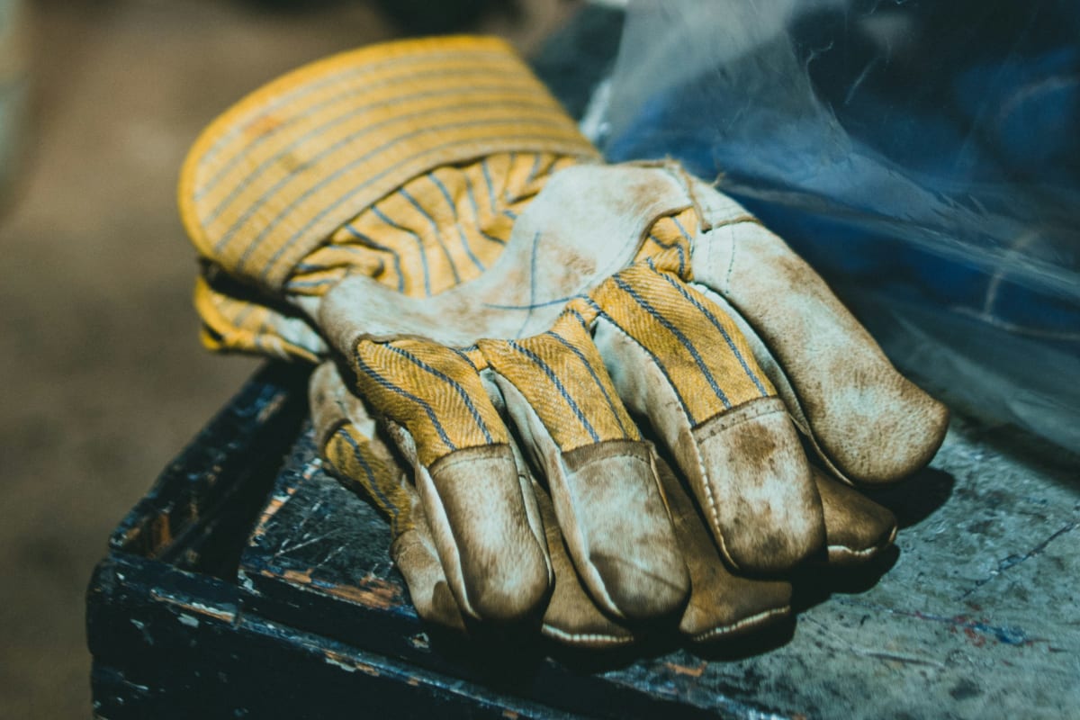 Worn leather-palm work gloves on the job