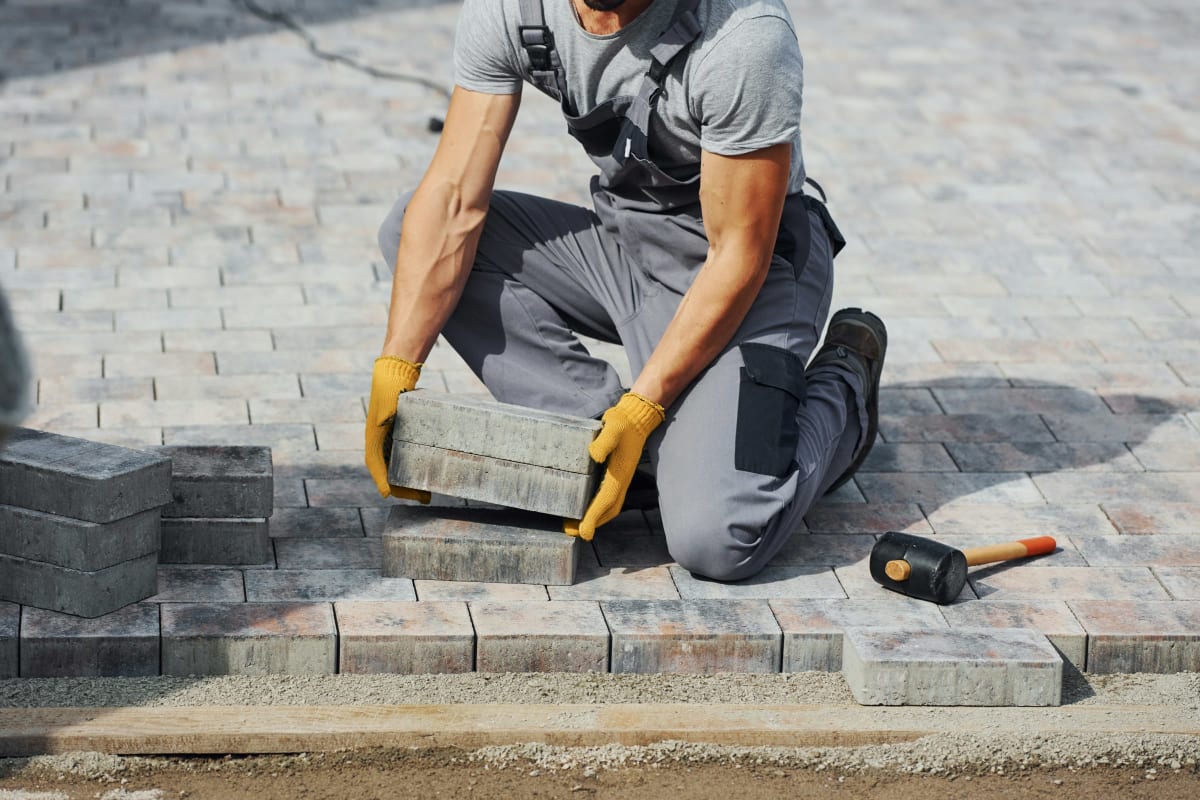 Installer setting pavers for a new patio