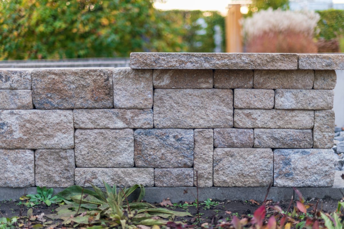 Segmental block retaining wall with a cap
