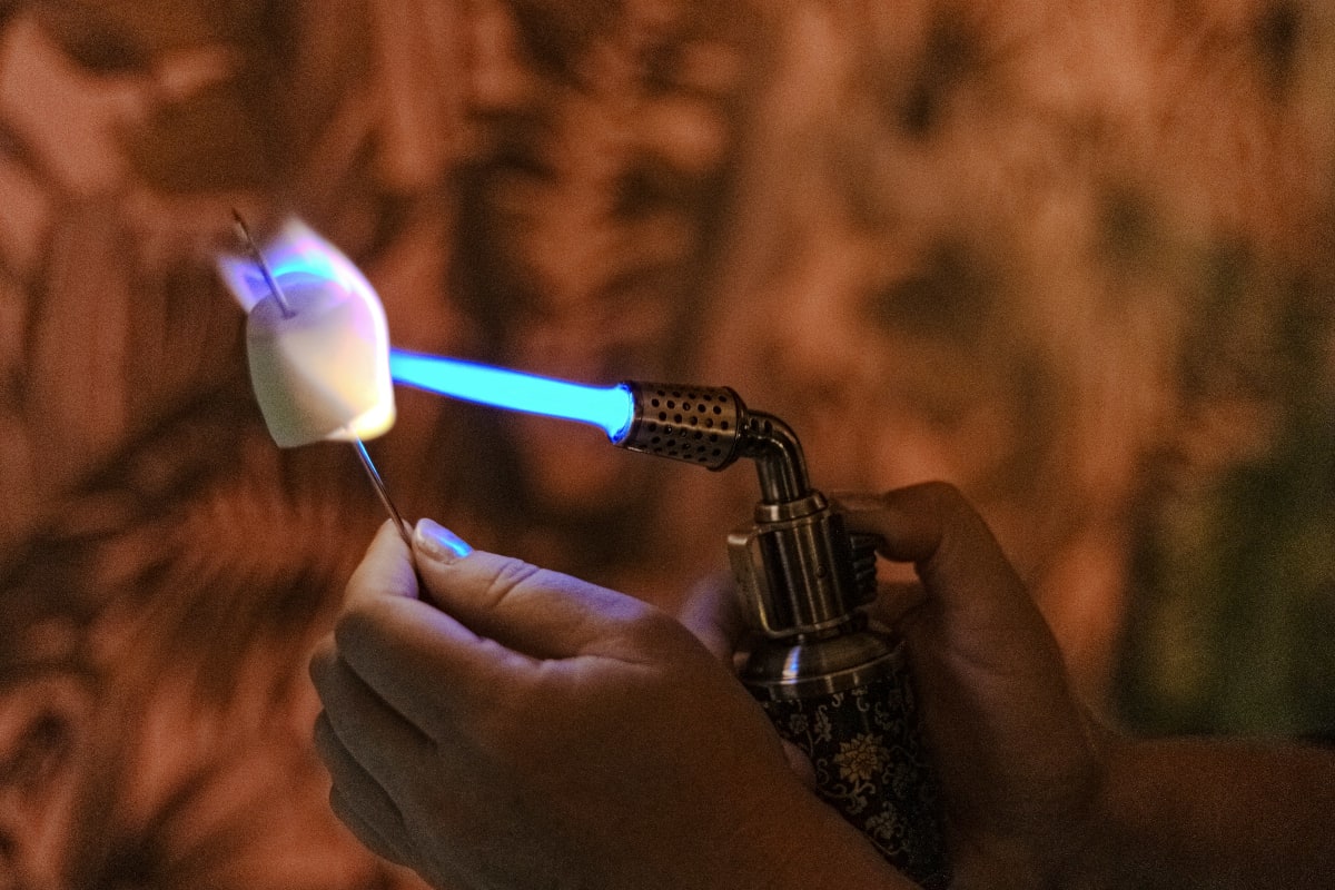 Toasting a marshmallow with a hand torch