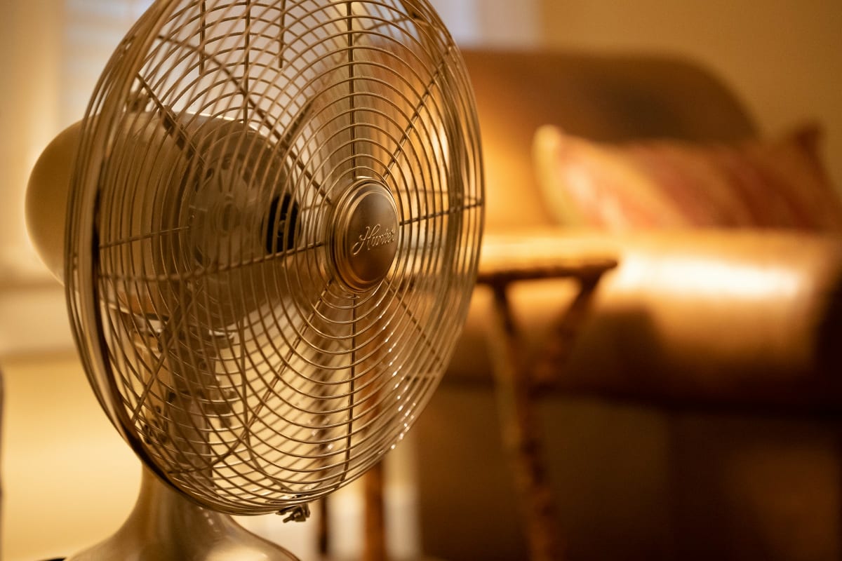 Fan by a cozy couch in warm evening light