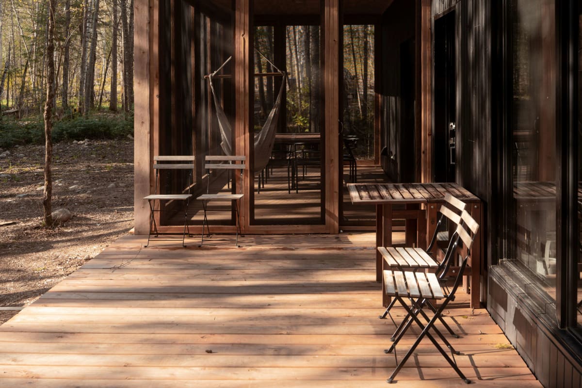Two-story home with dark wood siding and a screened porch