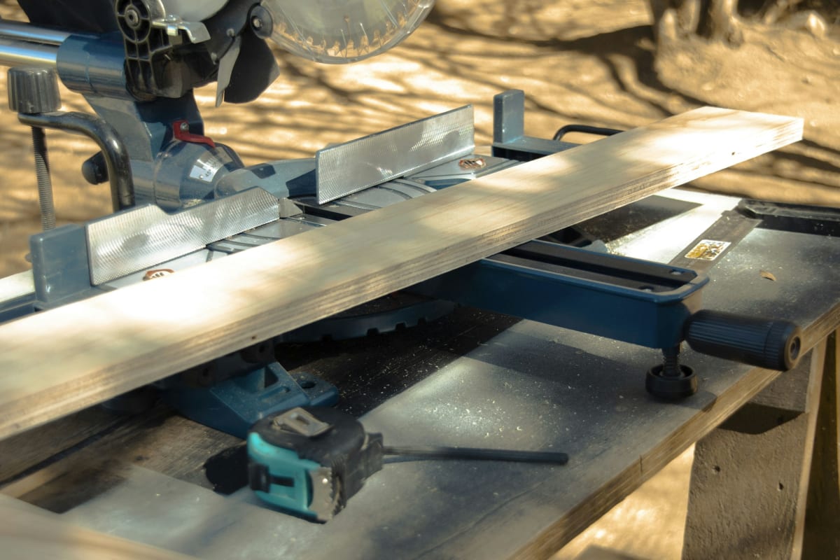 Miter saw on a stand cutting a long board