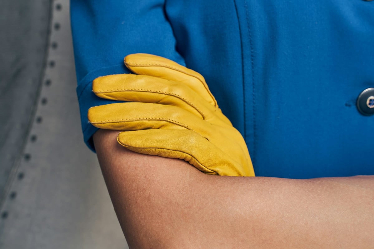 Yellow leather work glove on a crossed arm