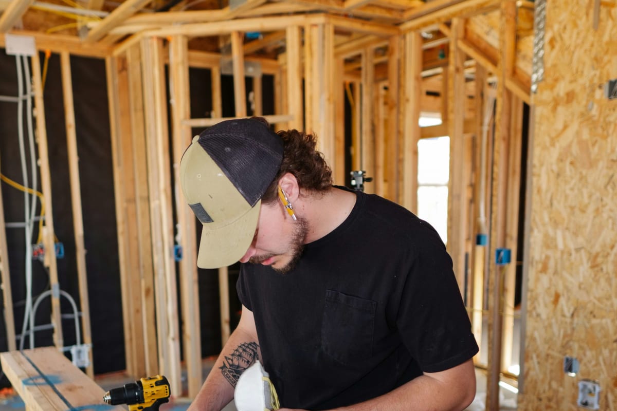 Builder at work inside a newly framed house