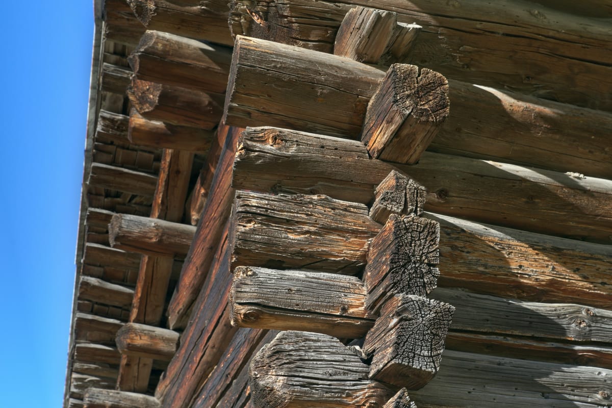 Stacked log corner against a blue sky