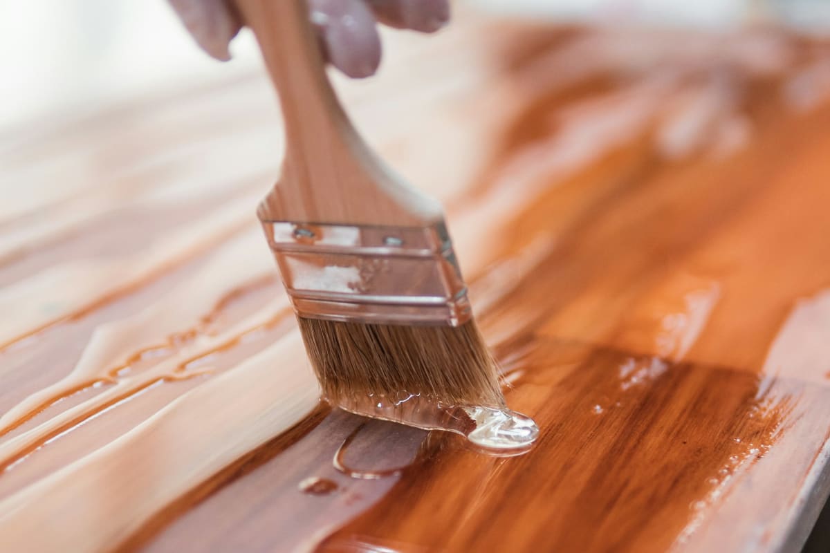 Brushing a glossy clear finish onto wood
