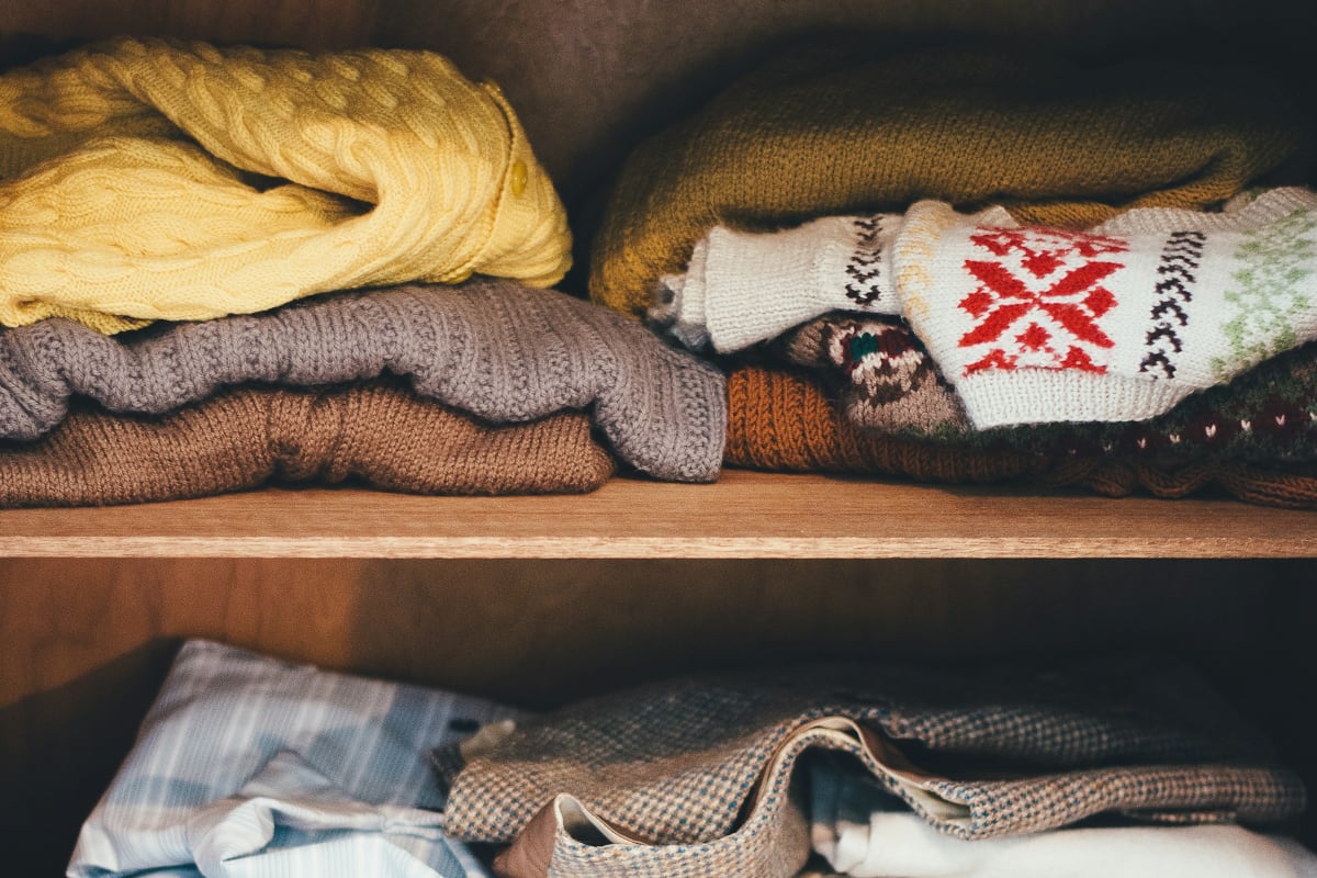 Sweaters folded on closet shelves