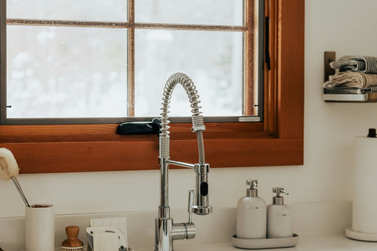 Pull-down faucet over a white kitchen sink