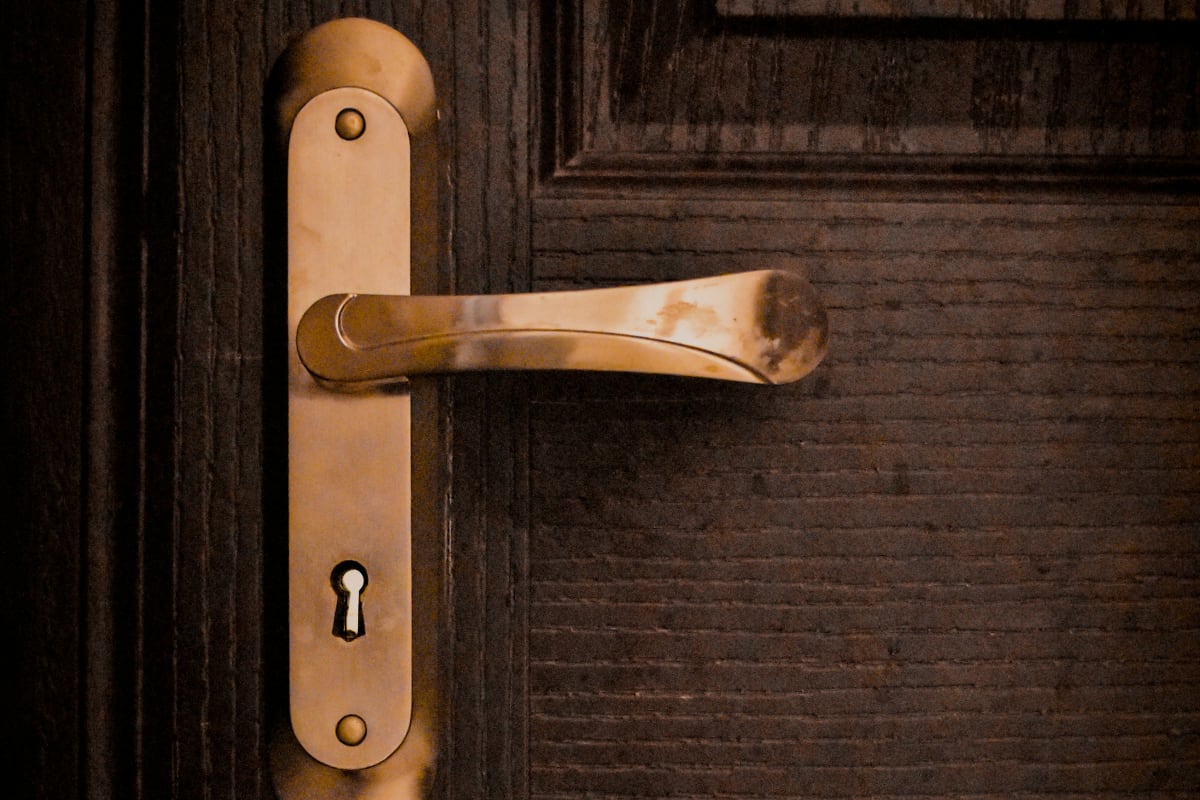 Copper lever handle and keyhole on a wood door