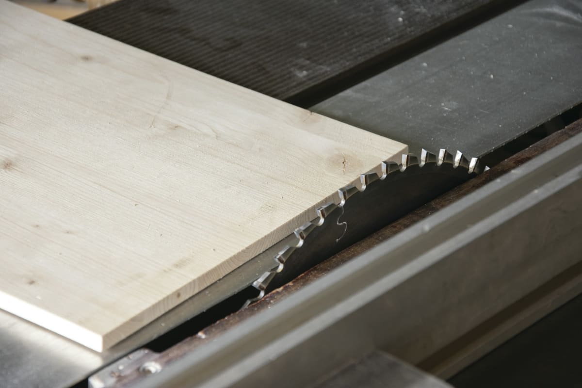 Table saw blade cutting a board