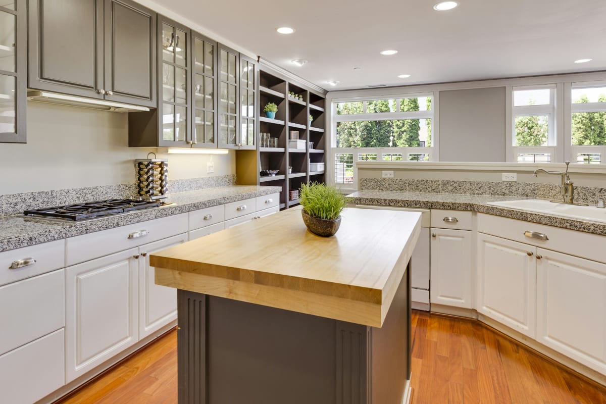 Finished kitchen with white cabinets and a wood island