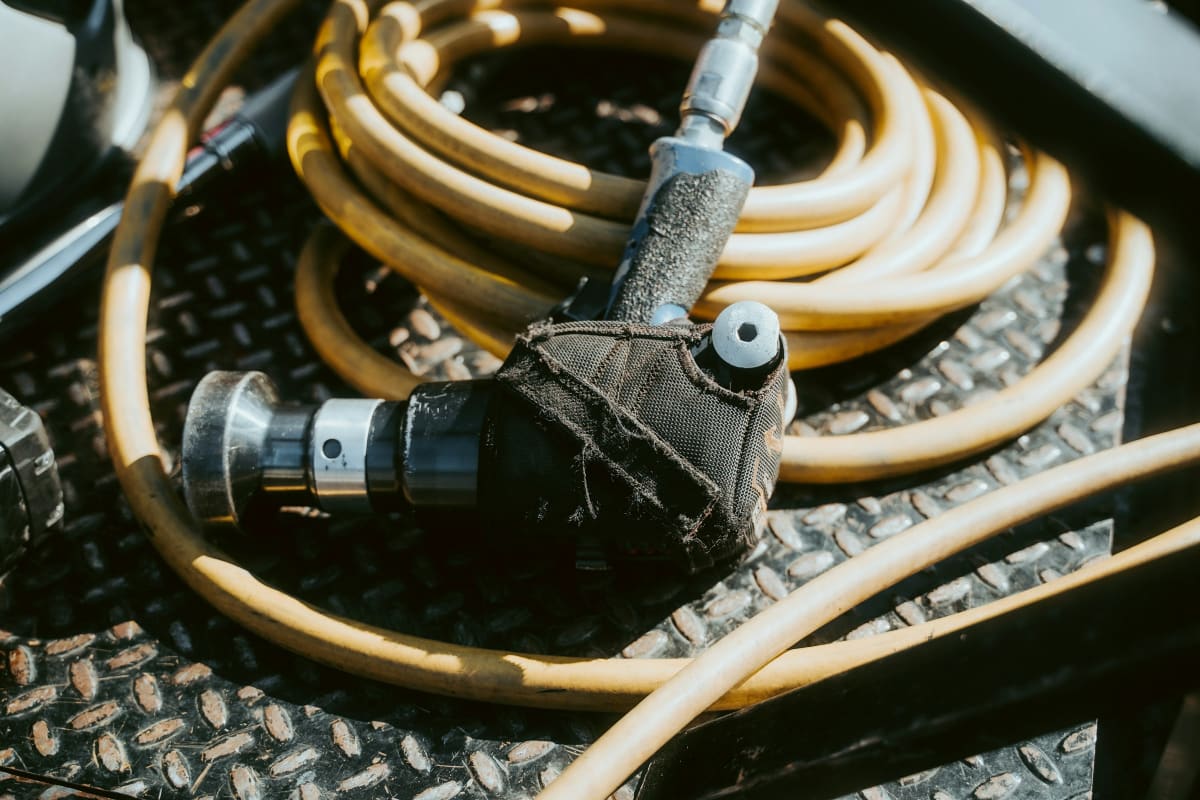 Coiled yellow air hose on a diamond plate deck