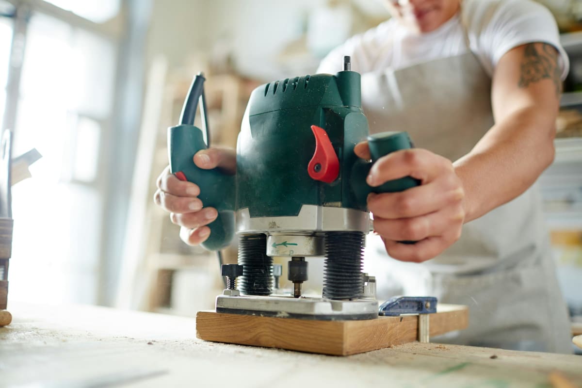 Woodworker routing a board