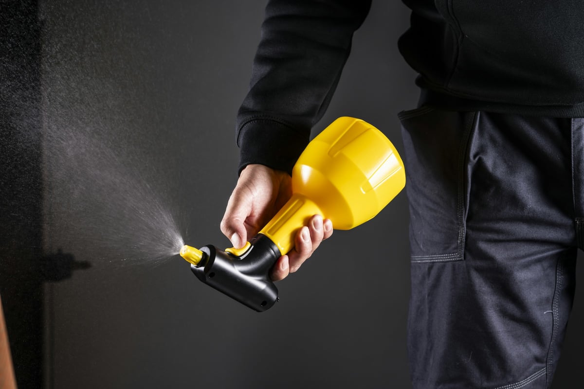 Handheld paint sprayer in action