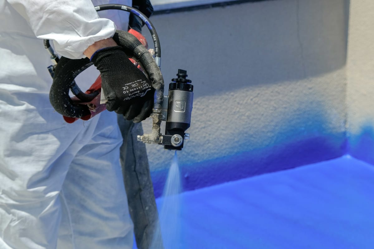 Spraying blue paint with a spray gun