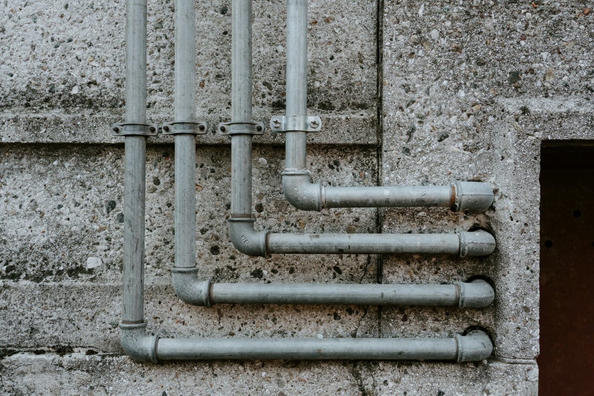 Metal conduit runs bent along a concrete wall