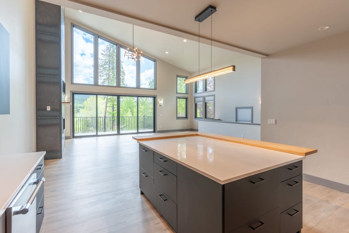 Kitchen island under recessed lights in a vaulted room