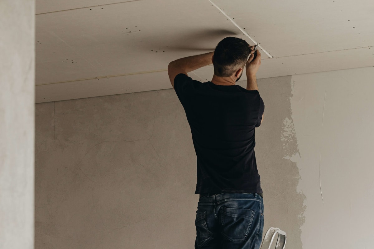 Smoothing compound on a wall from a ladder
