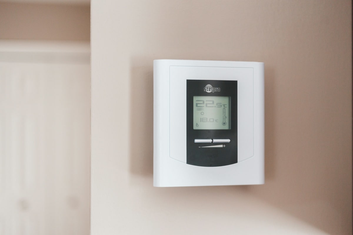 White programmable thermostat on a wall