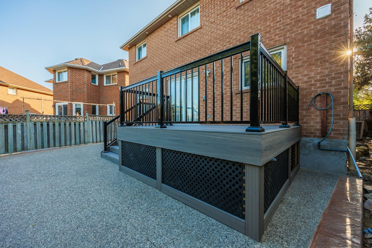 Raised deck with black railing and a lattice skirt