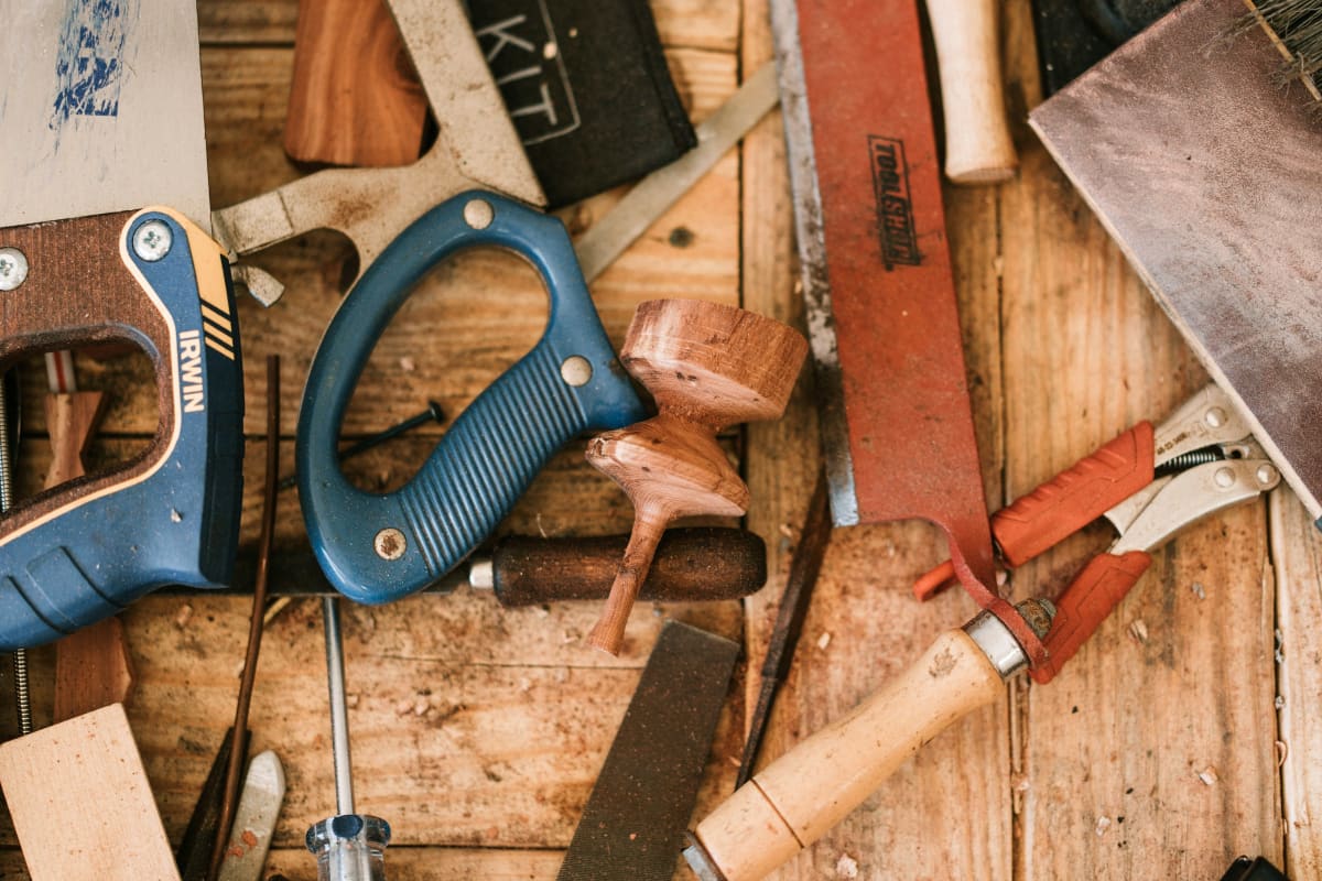 Hand saws with blue handles among woodworking tools