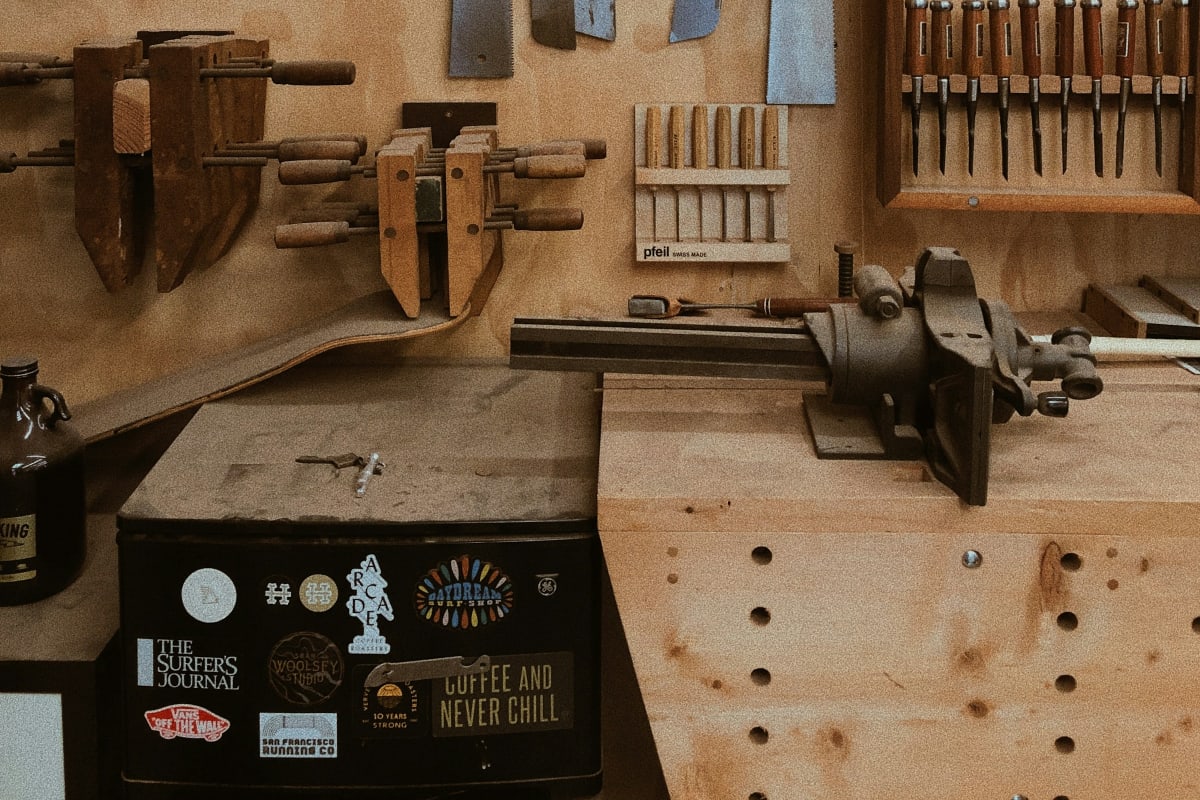 Saws, chisels and clamps hung on a workshop wall